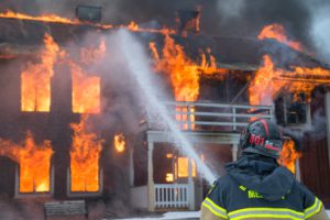 image of firefighter spraying fire